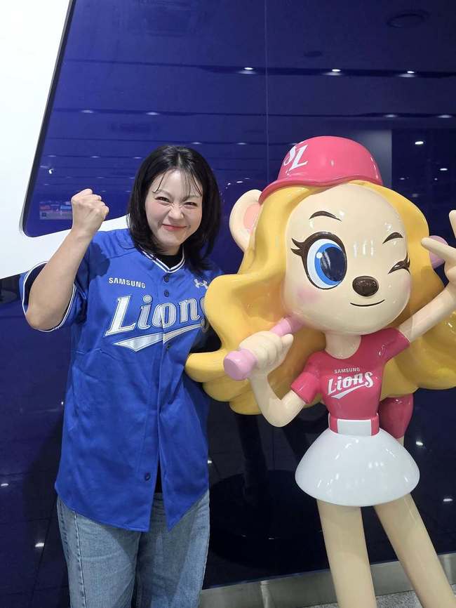 三星ライオンズの青いユニフォーム姿で球団マスコット像の隣に立つイ・ヨンヒョン。