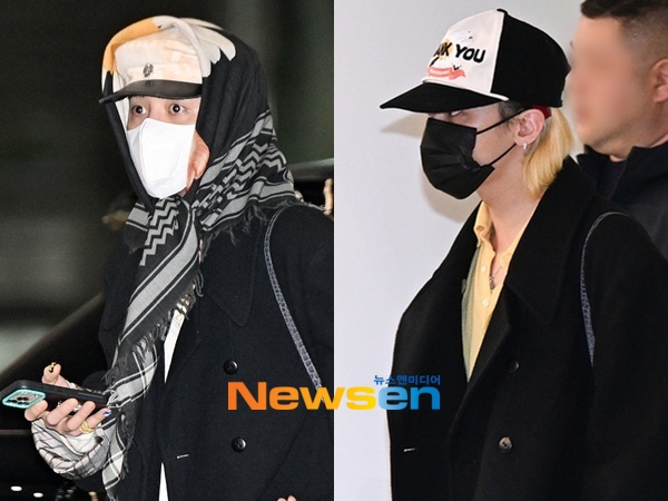 ハノイへ向かう出国時、黒いロングコートと柄スカーフ、白いキャップを合わせたG-DRAGON。ニュースエン掲載の出国・帰国写真のうち出国時の姿。