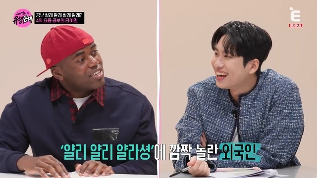 Eチャンネル『서인영의 유행꼰대』の番組画面。赤い帽子をかぶったジョナサンと黒髪の男性が机を挟んで笑っている