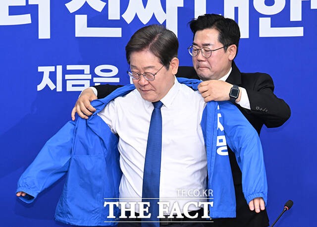이재명 더불어민주당 대선 후보가 4월 28일 오전 서울 여의도 국회에서 열린 더불어민주당 최고위원회의에 참석해 박찬대 더불어민주당 당대표 직무대행 겸 원내대표로부터 점퍼를 전달받고 있다./국회=박헌우 기자