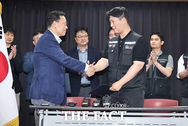 20일 경기도 수원시 장안구 경기고용노동청에서 열린 삼성전자 임금협상을 마친 후 여명구 삼성전자 DS부문 피플팀장(왼쪽)과 최승호 삼성그룹 초기업노동조합 삼성전자지부 위원장이 잠정 합의한에 서명한 후 손을 맞잡고 있