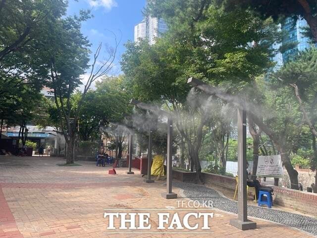 서울 용산구 동자동 쪽방촌 인근 새꿈어린이공원에 설치된 쿨링포그 아래 주민들이 더위를 피하고 있다./진주영 기자