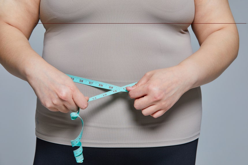 A person measures their waist in this image unrelated to the story. [GETTY IMAGES BANK]