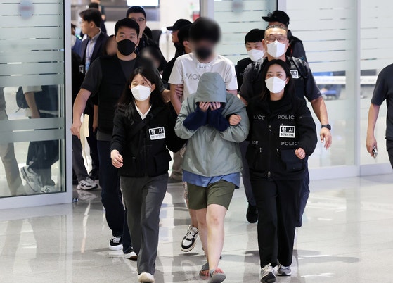 A total of 64 Korean nationals who were detained in Cambodia over their alleged involvement in online scams arrive at In