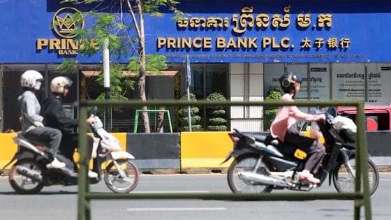 Commuters drive past Prince Bank in the Prince Group headquarters building in Phnom Penh, Cambodia o