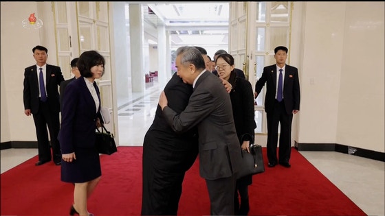 Kim Jong-un, left, bids goodbye to Chinese Foreign Minister Wang Yi during the minister's visit to P