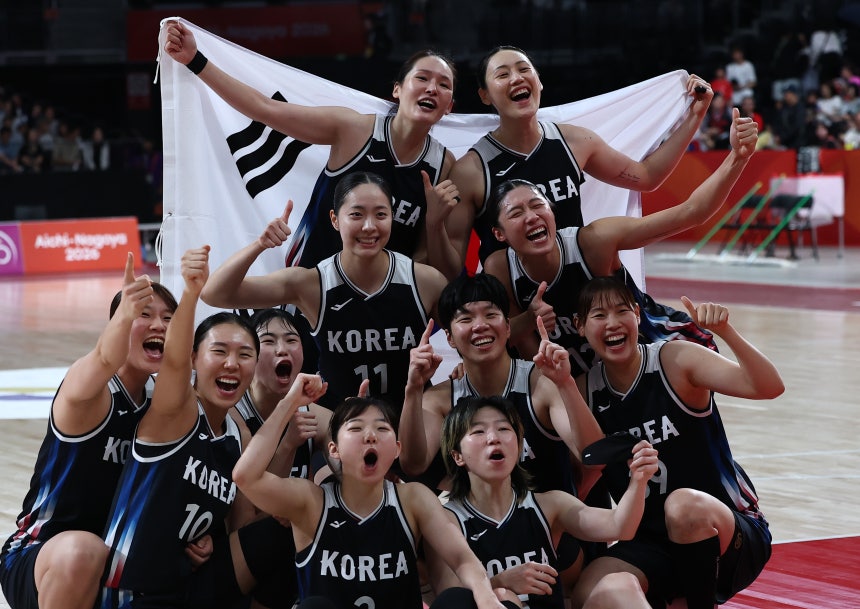 The Korean team celebrates after beating Japan 75-70 in the Asian Games women's basketball final at Aichi International 