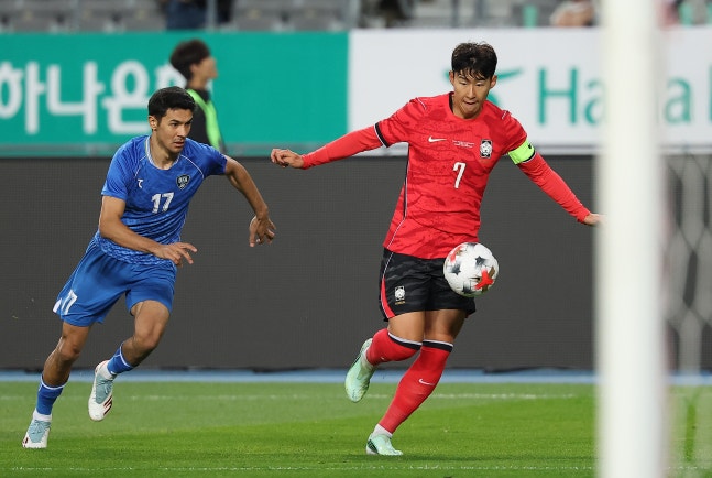 Son Heung-min, right, dribbles a ball during a friendly match against Uzbekistan in Yongin, Gyeonggi, on Oct. 6. YONHAP