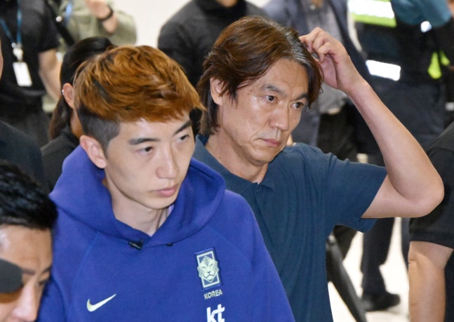 Goalkeeper Jo Hyeon-woo, left, arrives at Incheon International Airport after an early exit from the group stage at the FIFA World Cup 2026, with manager Hong Myung-bo on June 30. NEWS1