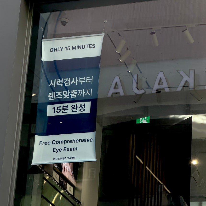 A sign reads that only 15 minutes is needed for an eye exam and glass prescription process in Myeongdong, central Seoul,