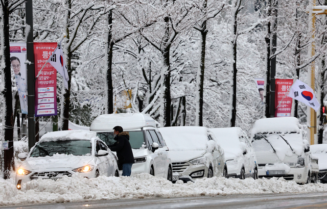 ▲在第三次降雪時,一個村民在gyo -dong的路邊拆除了一輛被困的汽車,gangneung -si,gangwon -do。Yonhap新聞