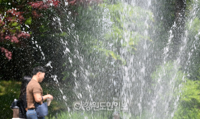 ▲ 강원지역 최고기온이 영상 20도를 넘으며 더운날씨를 보인 12일 춘천 강원도립화목원을 찾은 관광객들이 시원한 분수 옆을 지나고 있다.김정호 기자