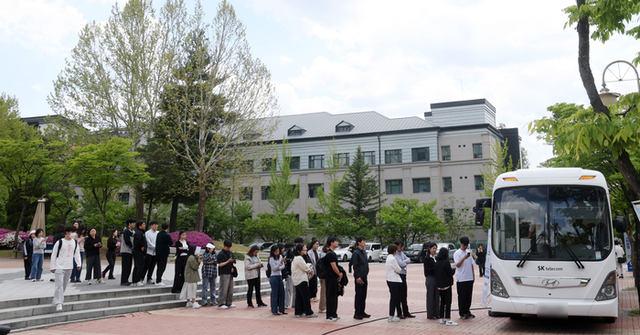 ▲ On the 7th, at Kangwon National University in Chuncheon, Gangwon Province, students and citizens are lined up as SK Telecom's mobile service bus offers USIM replacement services. Yonhap News