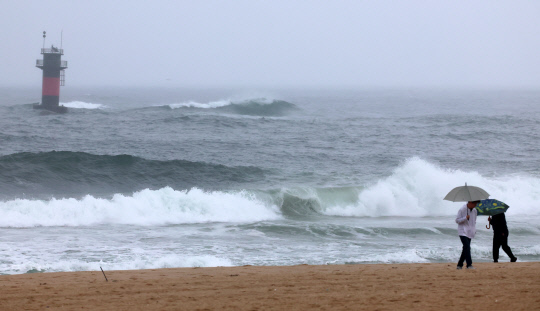 비가 오는 가운데관광객들이 해변을 걷고 있는 모습. 연합뉴스