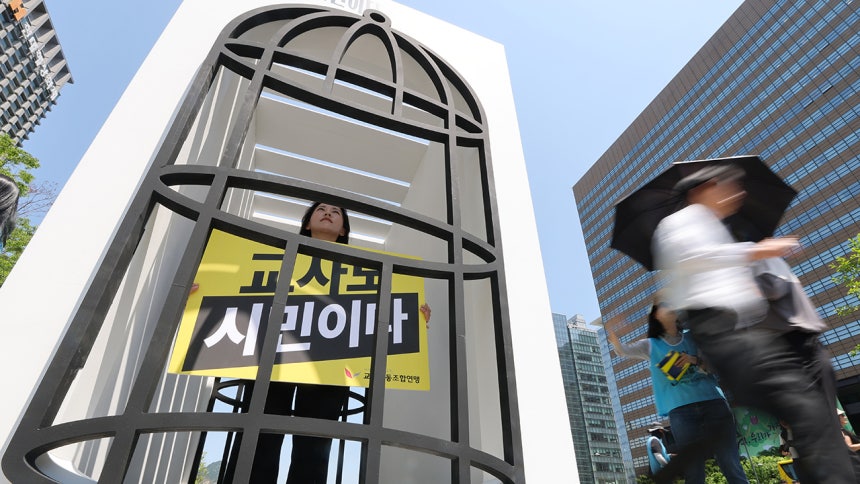 지난달 서울 종로구 광화문광장에서 교사노조연맹 주최로 열린 교사 시민권 회복 행사에서 송수연 교사노조연맹 위원장이 '새장에 갇힌 교사 시민권' 퍼포먼스를 하고 있다.연합뉴스
