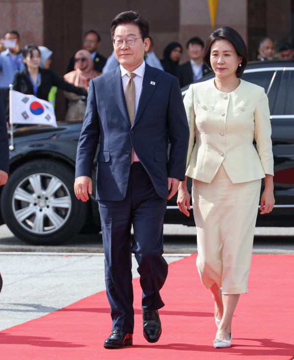아세안 정상회의 일정을 마치고 귀국하는 이재명 대통령과 김혜경 여사가 27일 말레이시아 쿠알라룸푸르 국제공항에서 공군 1호기로 향하고 있다.  연합뉴스