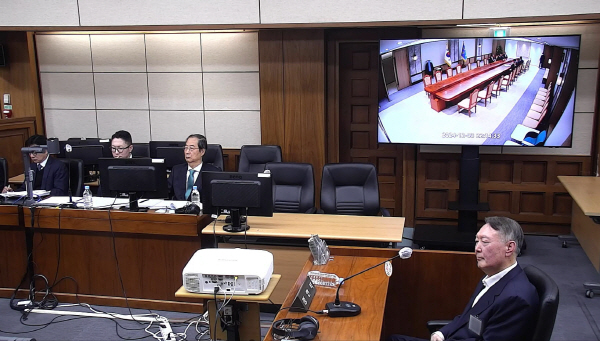 윤석열 전 대통령이 19일 서울 서초구 서울중앙지방법원에서 열린 한덕수 전 국무총리의 내란 재판에 증인으로 출석해 증거 CCTV 영상을 지켜보고 있다. 연합뉴스