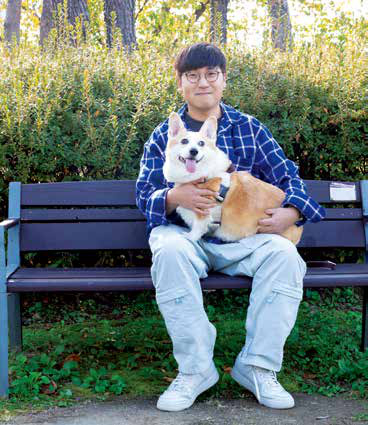 날씨 좋은 날,공원에서 한상훈 씨가 통통이와 사이좋게 앉아 있다.