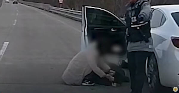 지난 4월13일 고양시의 한 자동차 전용도로에서 한 여성이 심장 고통을 호소하며 쓰러진 남편 A씨를 &#48677;잡고 울고 있다.현장에 도착한 경찰은 신속히 A씨를 병원으로 이송했다.경찰청 유튜브 갈무리